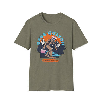 Heather green Sass-quatch graphic t-shirt showing a stylish Big Foot walking by a mountain stream.